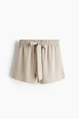 Short de sarga de tiro alto con corte holgado, cintura elástica y lazo decorativo frontal. Cuenta con bolsillos laterales discretos.