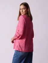 Blusa blanca con bordado calado tipo broderie, de mangas largas abullonadas.