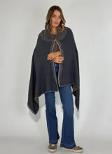 Ruana de lambswool color gris oscuro, con cuello alto y detalles bordados a mano en relieve en el cuello y a lo largo de la abertura frontal.