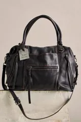 Bolso tote de cuero lavado negro con efecto gastado, interior amplio, bolsillos exteriores con cremallera, dos asas de mano y correa desmontable y regulable.