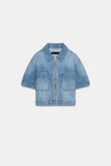 Camisa de denim de corte recto y manga corta, con cuello solapa, cierre frontal con cremallera y dos bolsillos delanteros de plastrón.