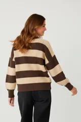 Sweater de punto grueso con diseño de rayas horizontales anchas en tonos bordó y rosado, de corte holgado, manga larga y cuello redondo a la base.