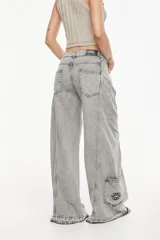 Jean de denim celeste de tiro alto y silueta wide leg, con costuras marcadas, bolsillos funcionales, bolsillo trasero inferior con bordado y terminación desflecada en el ruedo.