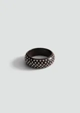 Pulsera rígida de resina color negro, con diseño abovedado y apliques de cristales brillantes distribuidos por toda la superficie.