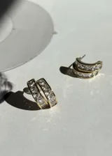 Par de aros tipo argolla dorados con incrustaciones de zirconias blancas. Cierre tipo mariposa y aguja de plata 925.