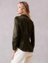 Camisa de satén color verde oliva, con cuello clásico, cierre frontal con botones metálicos y mangas largas con puños abotonados.
