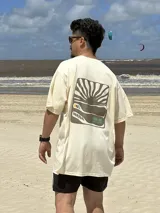 Remera color crema de algodón con estampa en la espalda de un paisaje playero con el texto "Chema Sure Chate et la mer".