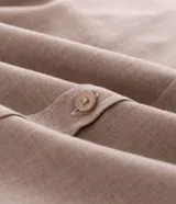 Camisa de manga larga con cuello inglés y cierre frontal de botones, confeccionada en tricolina de algodón color beige.