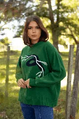 Sweater de lana merino color verde, con diseño de raíces en contraste en el frente, cuello redondo y corte holgado.