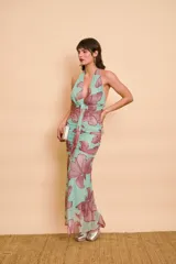 Vestido largo de fiesta de cuello halter, con estampado floral en tonos verde menta y bordó, fruncido en el cuerpo y talle largo.