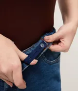 Pantalón de jean recto Ashua, color azul medio con efecto desgastado sutil. Presenta cintura con presillas, cierre frontal con botón y bolsillos funcionales.