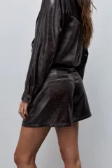 Short de tiro alto con silueta amplia, confeccionado en tela de acabado brillante y textura arrugada.