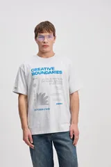 Remera oversize gris melange de algodón con estampa tipográfica frontal en color azul y gris.