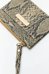 Billetera rectangular color bordó con estampado de piel de serpiente, cierre superior con cremallera, bolsillo frontal y correa de muñeca.