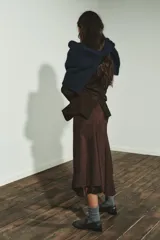 Falda midi de tiro medio con bajo asimétrico y cierre lateral con cremallera oculta. Presenta un acabado texturizado que simula el ante.