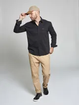 Camisa de manga larga color marrón, con cuello clásico, cierre frontal con botones y dos bolsillos frontales con solapa en el pecho.