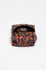 Neceser de estructura blanda con estampado de leopardo en tonos naranjas y azules. Presenta cierre de cremallera, bolsillo interior y logo metálico de Bimba y Lola.