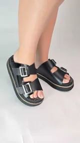 Zuecos de cuero color tostado con plataforma y dos tiras ajustables con hebillas metálicas plateadas.
