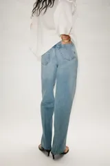 Jeans de tiro alto con diseño de cinco bolsillos y pernera recta. Presenta una raya planchada a lo largo de la pierna y cierre frontal con cremallera y botón.
