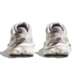 Championes Hoka modelo Kawana 2, color gris claro con detalles en azul y blanco. Presenta una suela con diseño moteado y logo de la marca en el lateral.