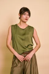 Blusa verde militar sin mangas, de corte holgado y diseño fluido, con detalle de ribete texturizado en el cuello y las sisas.