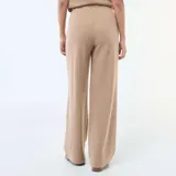Pantalón wide leg de punto suave color beige, con cintura elástica y diseño fluido.