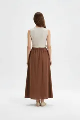 Falda larga de algodón color marrón, con cintura elástica con punto smock y caída amplia.