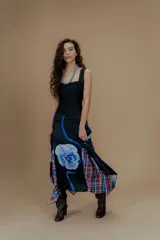 Falda larga de seda negra con estampado floral azul y detalles de tela escocesa en el ruedo.