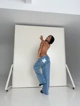 Pantalón de jean celeste con apliques de estrellas blancas en la parte trasera.