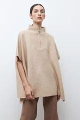 Sweater oversized color verde petróleo, con cuello alto y cierre frontal corto.