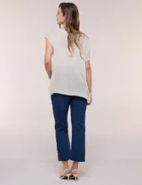 Blusa negra de tejido de punto fino con hilos de lúrex brillante, escote redondo amplio, mangas cortas con hombros caídos y silueta semi holgada.