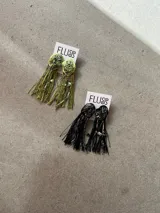 Par de caravanas colgantes artesanales con base texturizada, flecos de hilo, cadenas y cuentas decorativas.