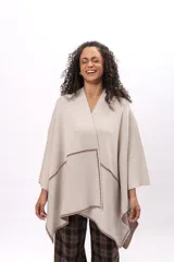 Ruana de algodón en color beige con detalles de costura decorativa en contraste color marrón. Presenta un diseño abierto con caída fluida y mangas tipo capa.
