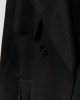 Campera tipo trench negra a la cadera, con solapa cruzada, doble botonadura frontal, hombreras y bolsillos delanteros con solapa.