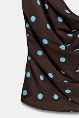 Top de escote drapeado con tirantes finos ajustables, confeccionado en tela fluida con estampado de lunares.