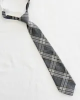 Corbata infantil gris con diseño a cuadros blancos y marrones, con elástico ajustable.