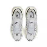 Championes Nike V2K Run de estilo retro-futurista, con diseño en capas de malla y material sintético en tonos beige y gris. Presenta una entresuela robusta con tecnología Cushlon y el logo de Nike en el lateral.