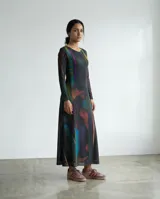 Vestido largo de corte recto y silueta fluida, confeccionado en jersey suave. Presenta un diseño de manga larga, cuello redondo y una estampa abstracta con trazos verticales en tonos oscuros, azules, verdes y rojizos.
