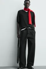 Pantalón de corte balloon fit y estilo relajado, confeccionado en tejido de algodón. Presenta pliegues frontales, cintura con trabillas, cierre frontal con cremallera y botón, bolsillos delanteros y bolsillos traseros de vivo.