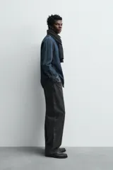 Camisa de corte relajado confeccionada en denim de algodón, con cuello solapa, manga larga con puños abotonados y cierre frontal de botones.
