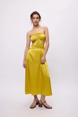 Vestido midi amarillo de satén con escote halter, trenzas en cuello y cintura, cut-outs laterales y falda recta.