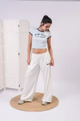 Pantalón de jogging blanco de pierna ancha y corte recto, con cintura elastizada y cordón de ajuste interno. Cuenta con un pequeño logo bordado en la parte superior izquierda.