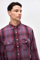 Sobrecamisa de algodón con diseño a cuadros en tonos azules, cuello clásico, cierre frontal con botones y dos bolsillos en el pecho con solapa.