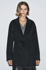 Blazer Zara de corte entallado confeccionada en mezcla de lana. Presenta cuello con solapa de muesca, manga larga y cierre frontal con un solo botón.