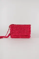 Cartera bandolera fucsia de trapillo crochet, forrada y con cierre de botón imán. Tiene correa de cadena plateada con detalles de trapillo.