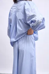 Pantalon de corte ancho y tiro alto, color azul marino, con bordados florales en color crema en la parte inferior de las piernas.