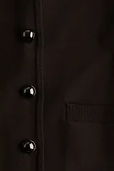 Saco corto de punto fino color marrón oscuro, con cuello de pelo sintético marrón oscuro y cierre frontal de botones metálicos. Posee bolsillos delanteros insertados.