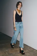 Jeans de tiro alto y corte ancho (wide leg) hasta el tobillo, confeccionados en denim azul de efecto lavado. Presenta cinco bolsillos y cierre frontal con cremallera y botón.