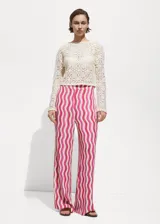 Pantalon wideleg de tiro medio con cintura elástica, confeccionado en tejido fluido de viscosa con estampado de ondas verticales en tonos fucsia, rosa y naranja.