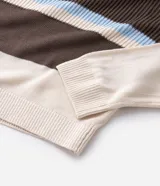 Suéter de punto texturizado con diseño de rayas horizontales en tonos marrón, crema y celeste. Presenta cuello polo con abertura frontal, mangas largas y terminaciones acanaladas en puños y dobladillo.